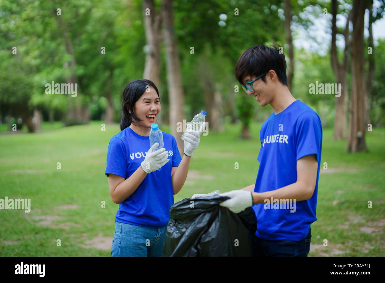Multiethnic volunteers donate their time holding black garbage bags to