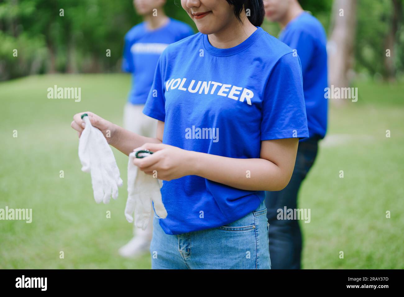 Multiethnic volunteers donate their time holding black garbage bags to