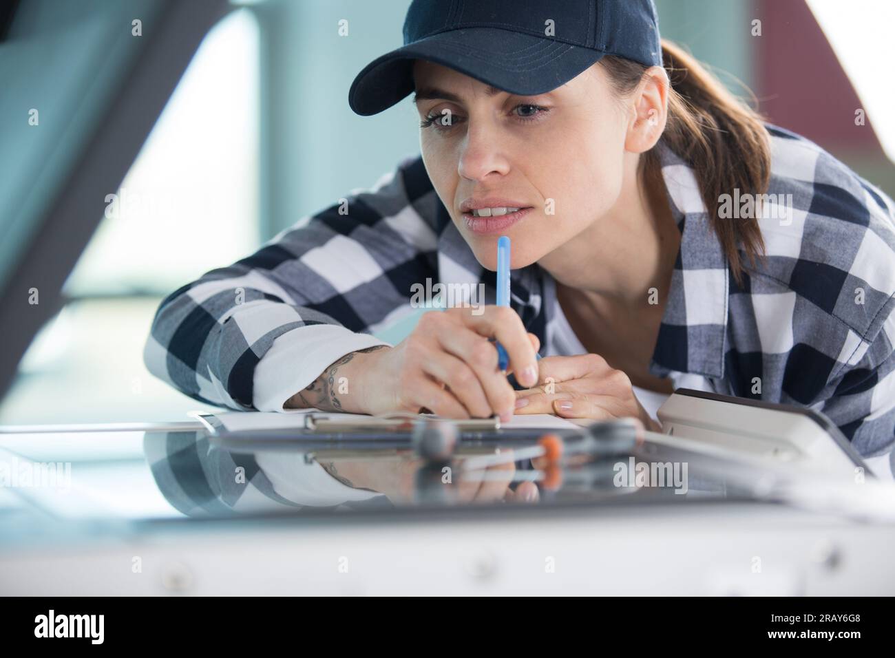 young woman adjusts settings on plotter in printing office Stock Photo