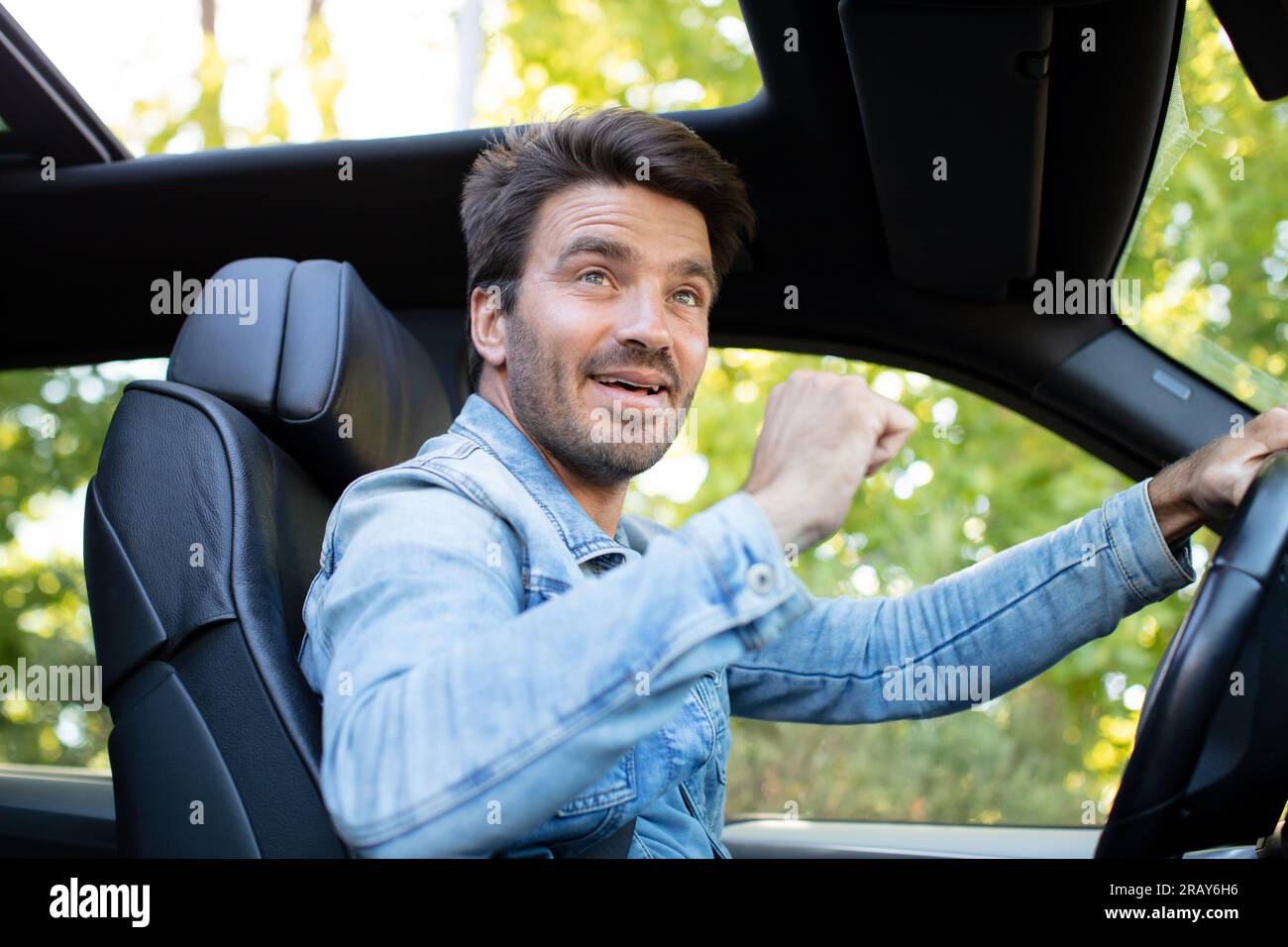 happy young driver behind the wheel of a car Stock Photo - Alamy