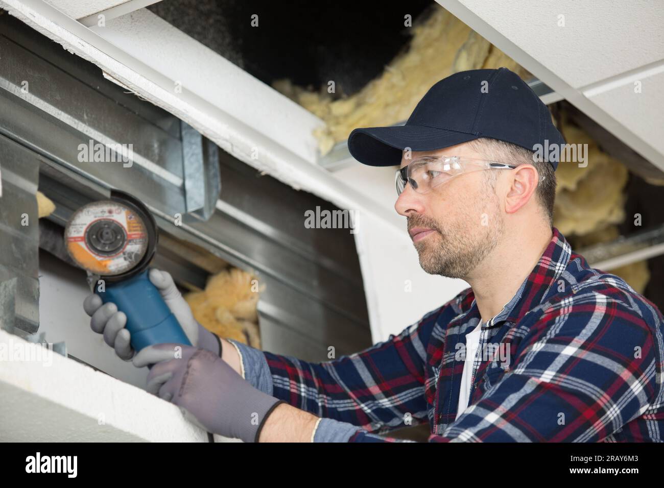 workman using angle grinder on metal Stock Photo