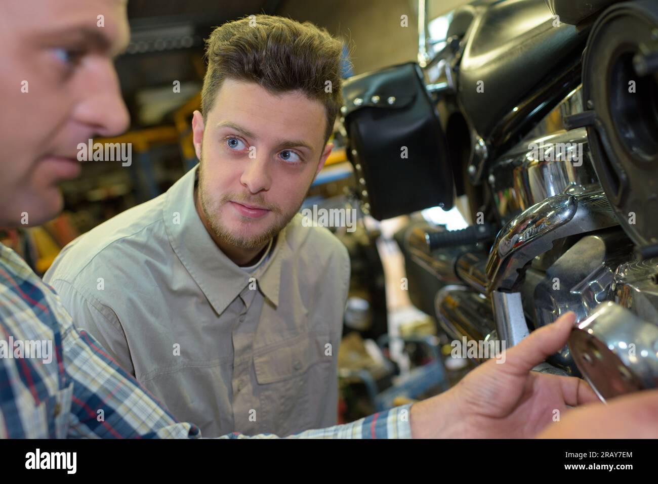 two mechanics in a motorbike garage Stock Photo Alamy