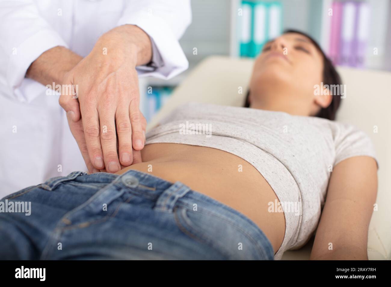 hands massaging a female abdomen Stock Photo