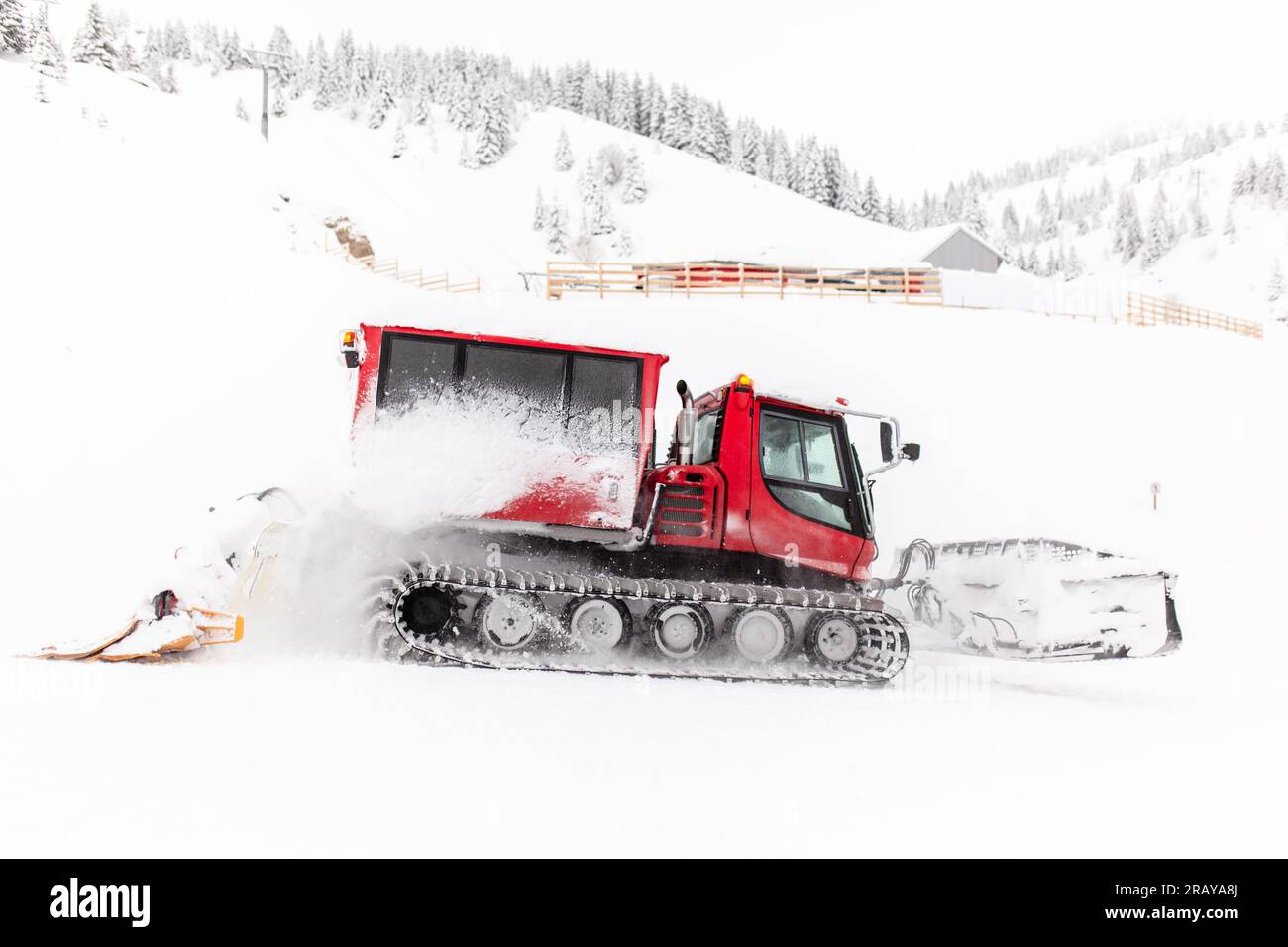Red snowcat vehicle preparing ski slopes. Stock Photo