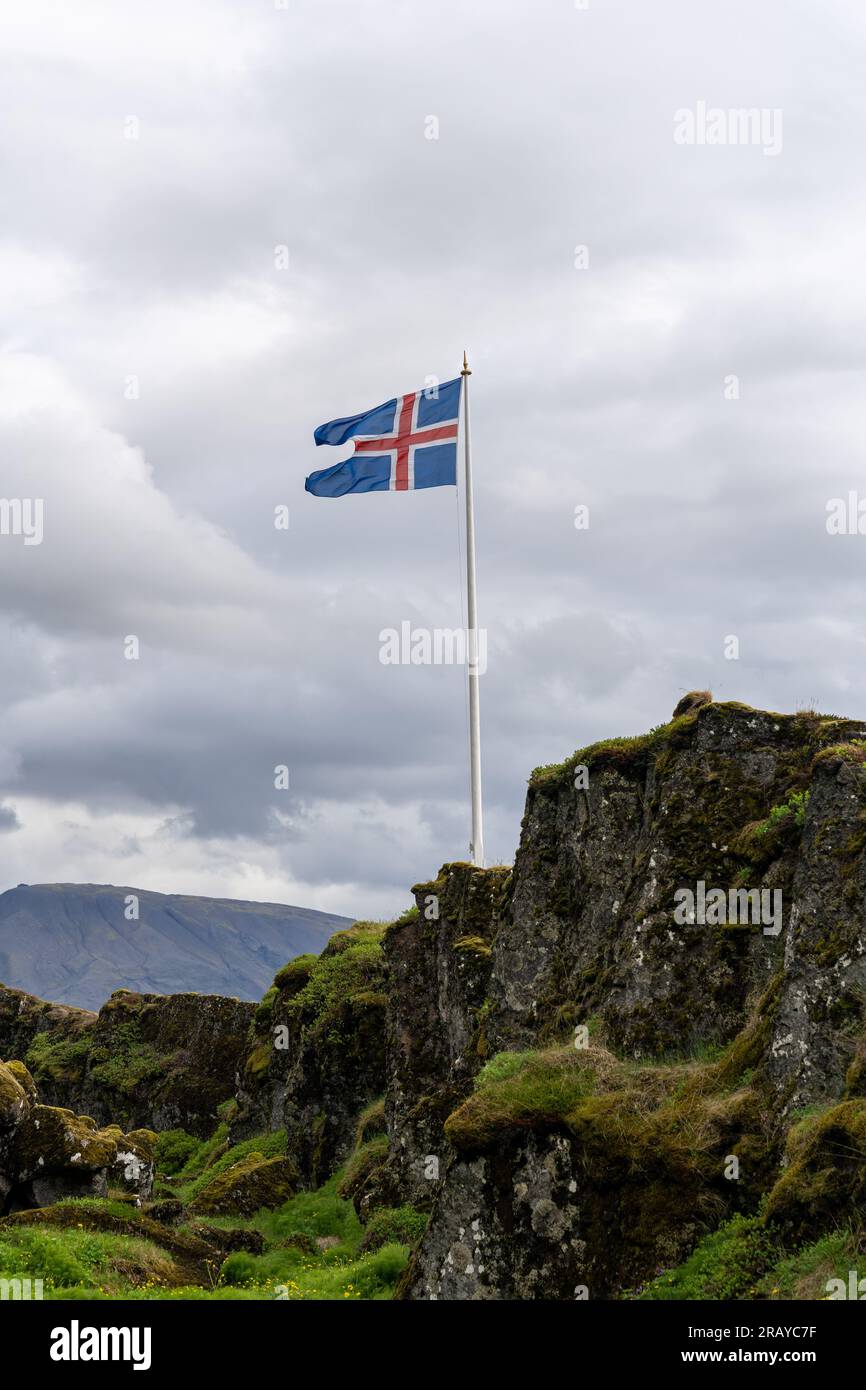 Icelandic flag waving in wind at Thingvellir rift valley of the mid Atlantic ridge in Iceland Stock Photo