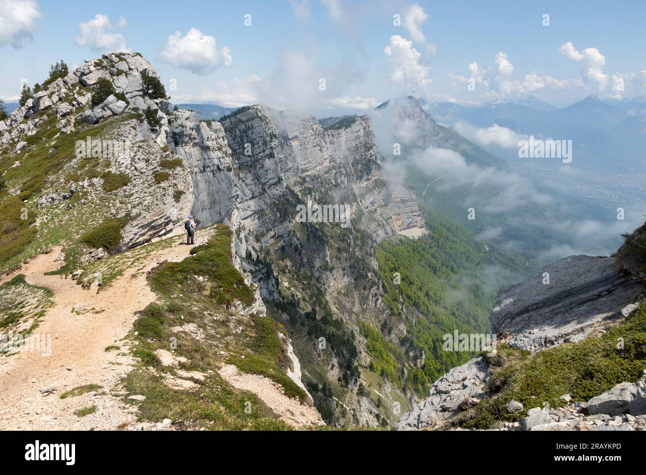 Walker enjoying the view north from the upper slopes of the Pic Saint Michel (alt 1,966m) towards the mountain of Moucherotte, Vercors Massif, Lans en Stock Photo