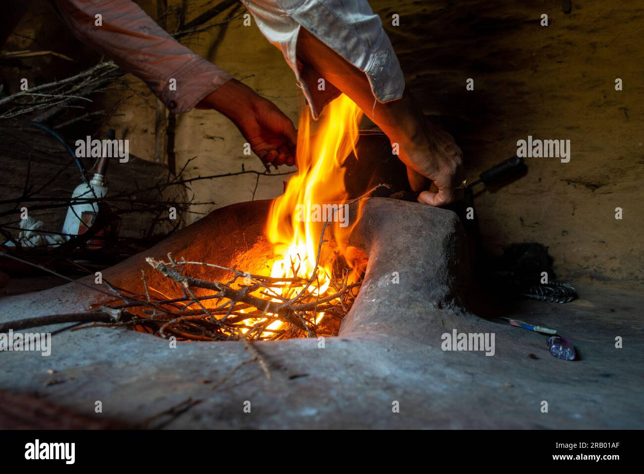 A burning clay stove fireplace inside a mud house in a rural village of Uttarakhand, India. Stock Photo