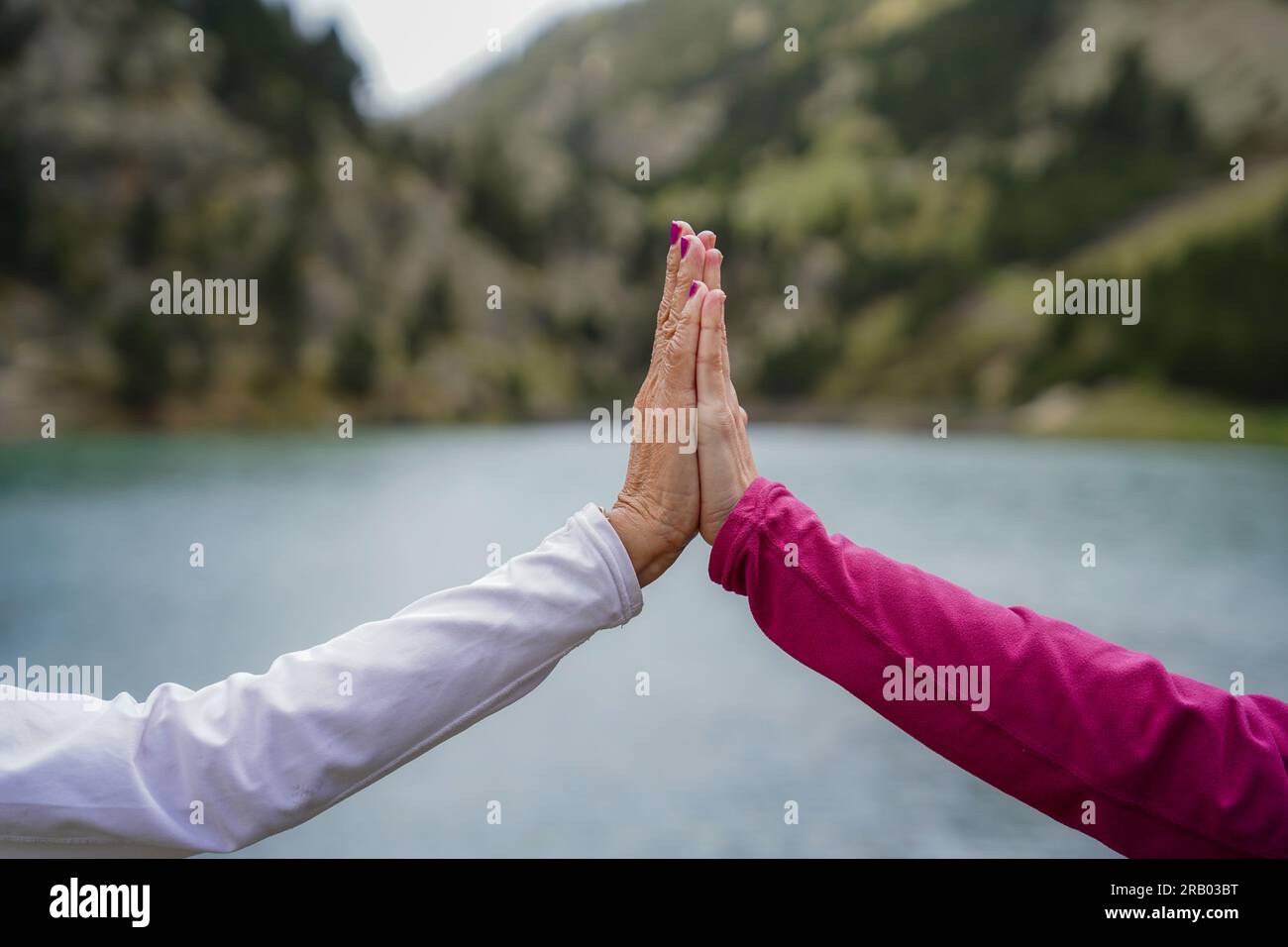 two hands of women in union and fellowship in a mountain scenery