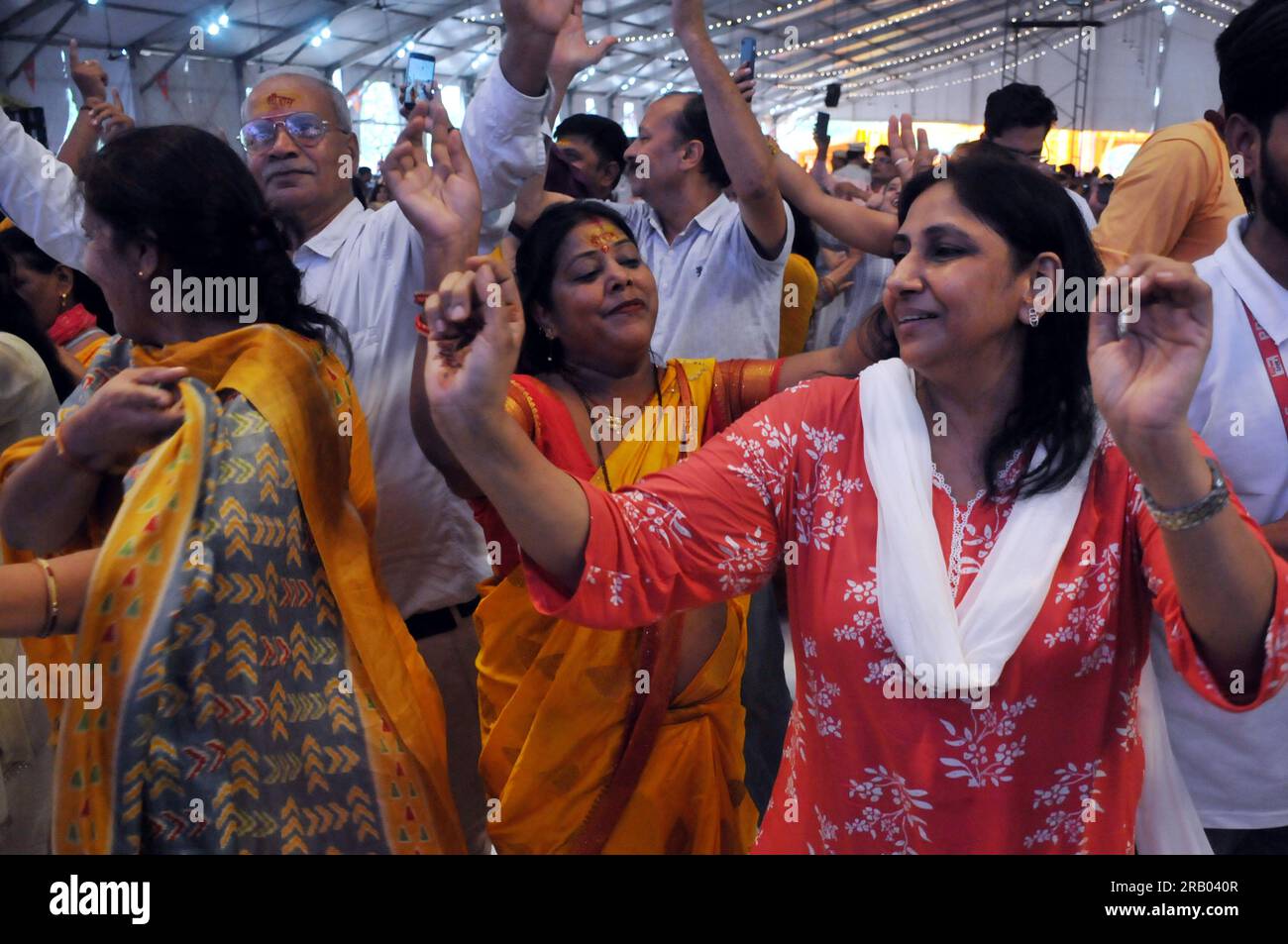 East Delhi, Delhi, India. 6th July, 2023. Devotees Dancing during the Lord Hanuman devotee Pandit Dhirendra Shastri blessing and being Greeted by Devotees during arrival for Three Day Katha Vachan.Pandit Dhirendra Krishna Shastri of Bageshwar Dham at Ramlila Maidan, IP Extension, Delhi. Divine Darbar, Kalash Yatra and Havan are also being organized in this. According to the local people, people from all the surrounding areas including Delhi are reaching here.Pandit Pandit Dhirendra Krishna Shastri will be present at the Divya Darbar at the venue of the event. Big screens are being installed Stock Photo