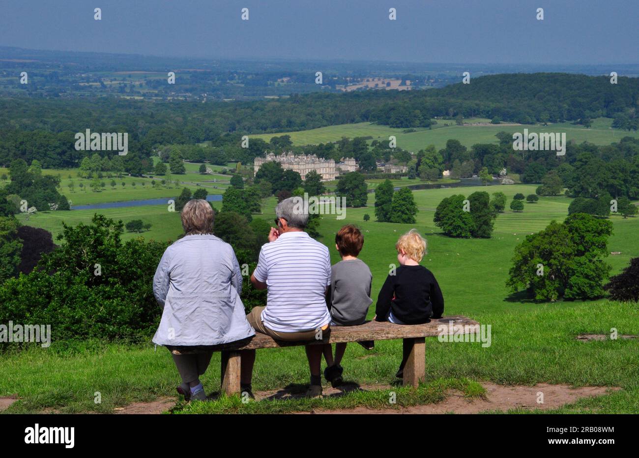 A family seated enjoying the magnificent view from Heavens Gate the hill overlooking Longleat the country home of Lord Bath in Wiltshire. Stock Photo