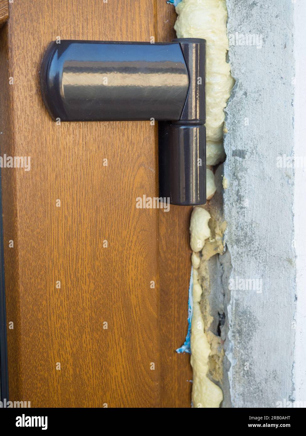 Close up of plastic doors and curtains with mounting foam, installing doors outside on the street. Mounting the frame with polyurethane foam. Construc Stock Photo