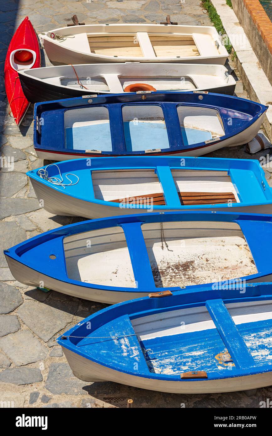Group of small old row boats moored on the quay of the port. Ancient Tellaro village, Lerici municipality, La Spezia province, Liguria, Italy, Europe. Stock Photo