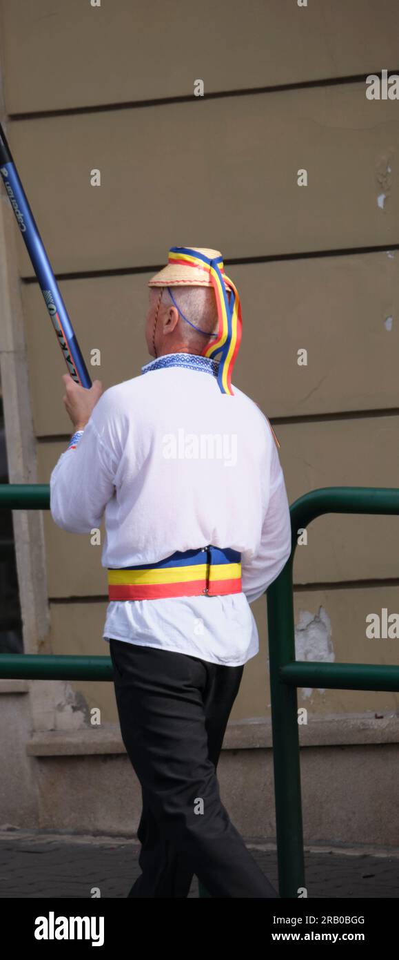 man in traditional costume in Romania walking the national flag Stock Photo