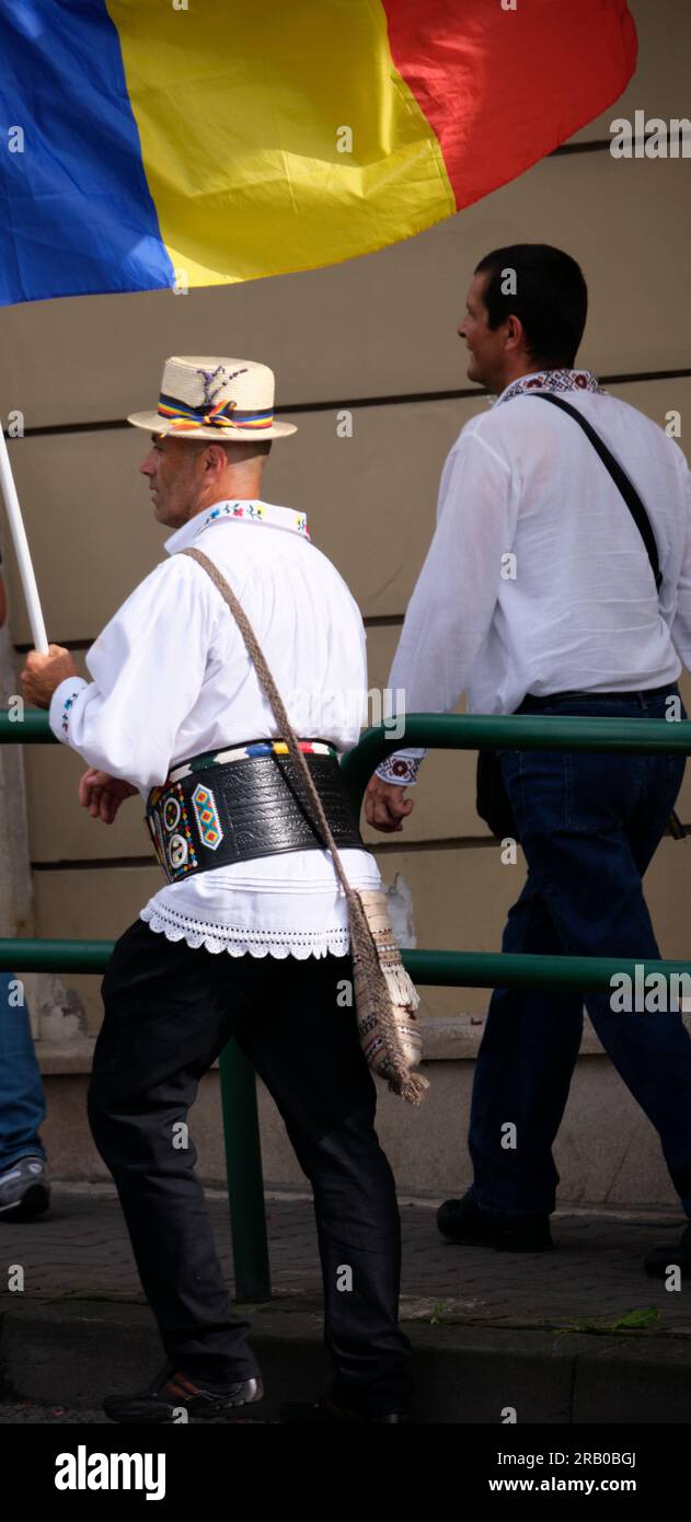 man in traditional costume in Romania walking the national flag Stock Photo