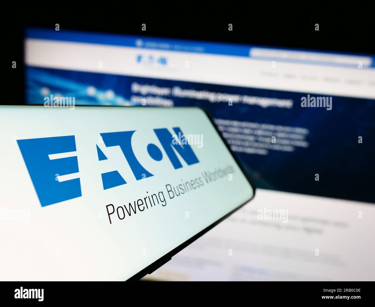 Mobile phone with logo of power management company Eaton Corporation plc on screen in front of business website. Focus on left of phone display. Stock Photo