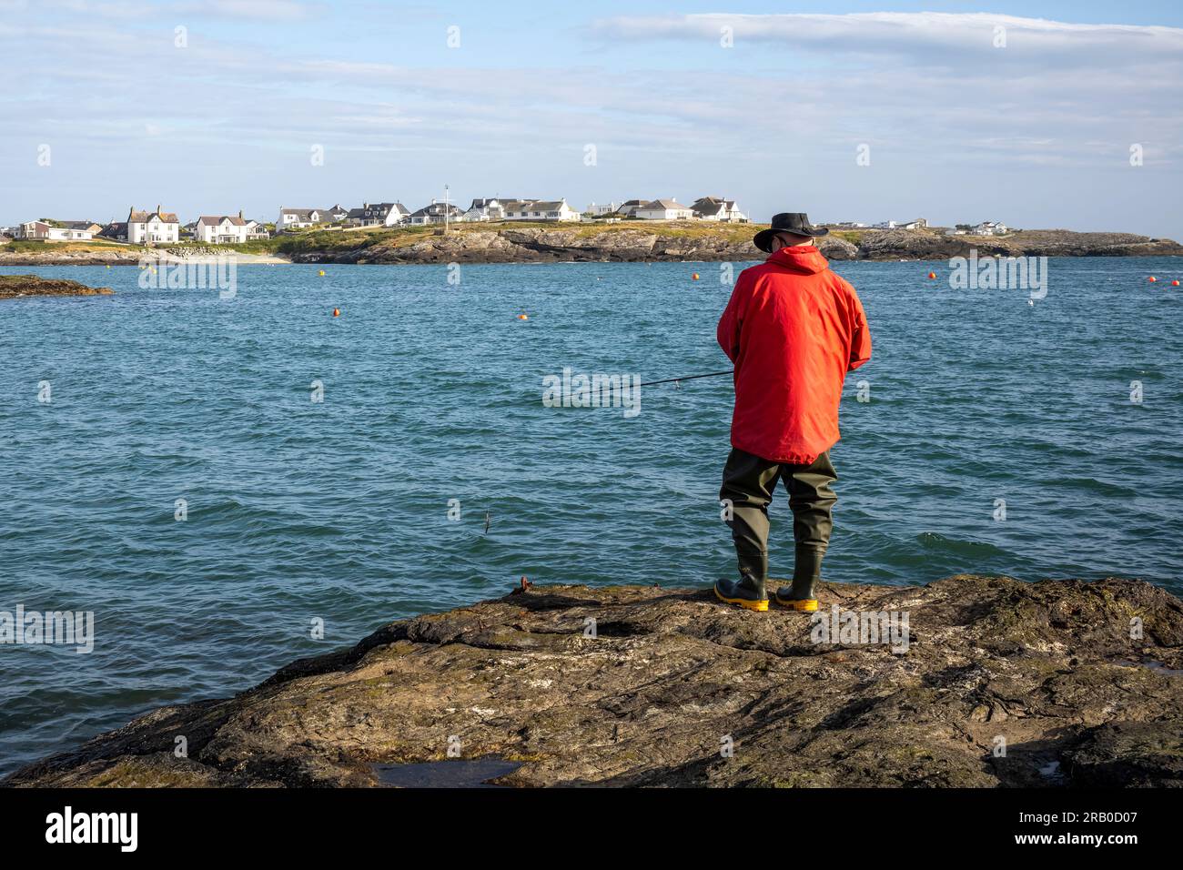 Fishing 'off the rocks' at Trearddur Bay, Holy Island, Anglesey, Wales, UK Stock Photo