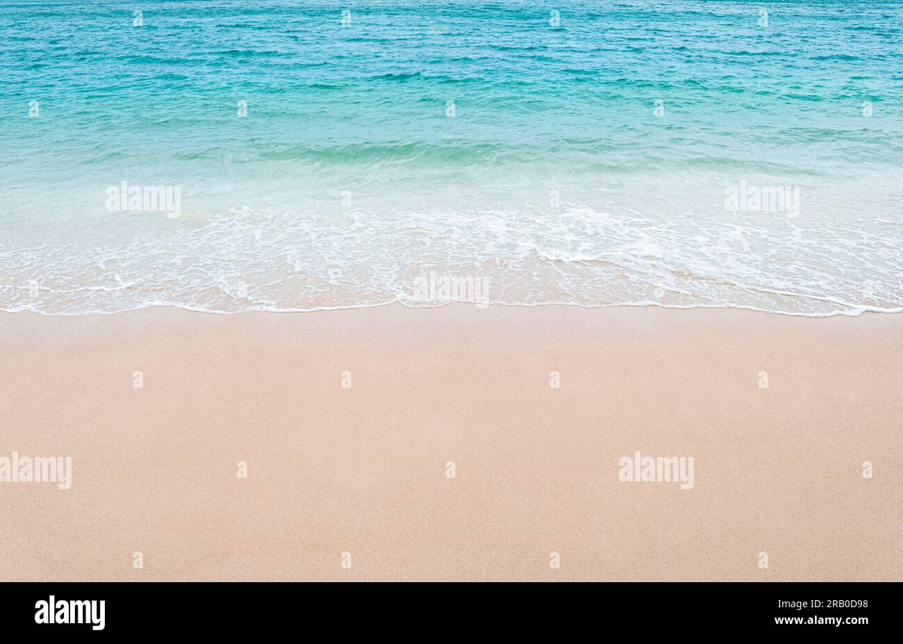 Beautiful sandy beach and soft blue ocean wave. Copy space. Stock Photo