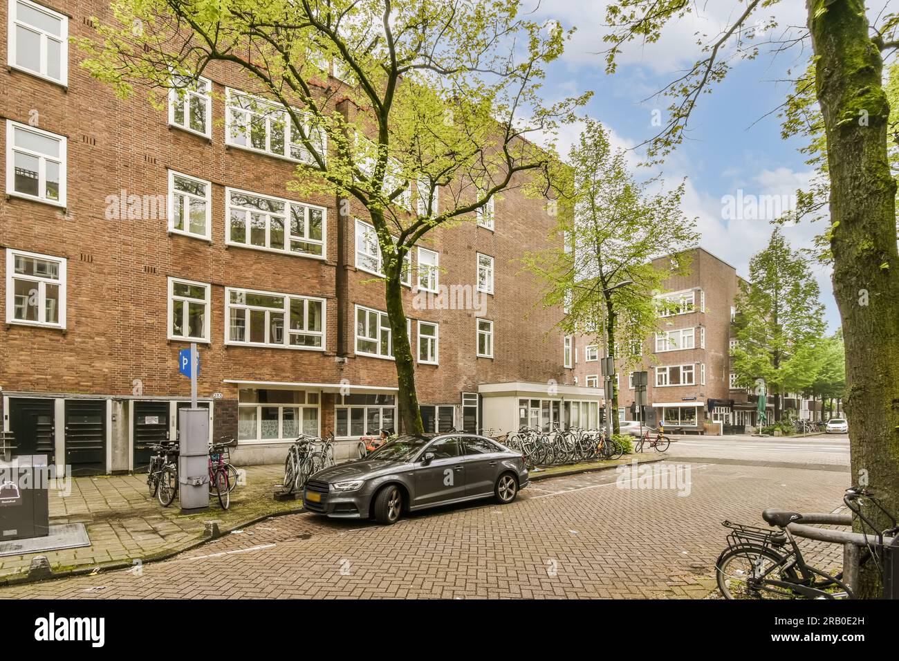 a city street with parked cars and bicycles on the sidewalk in front of ...