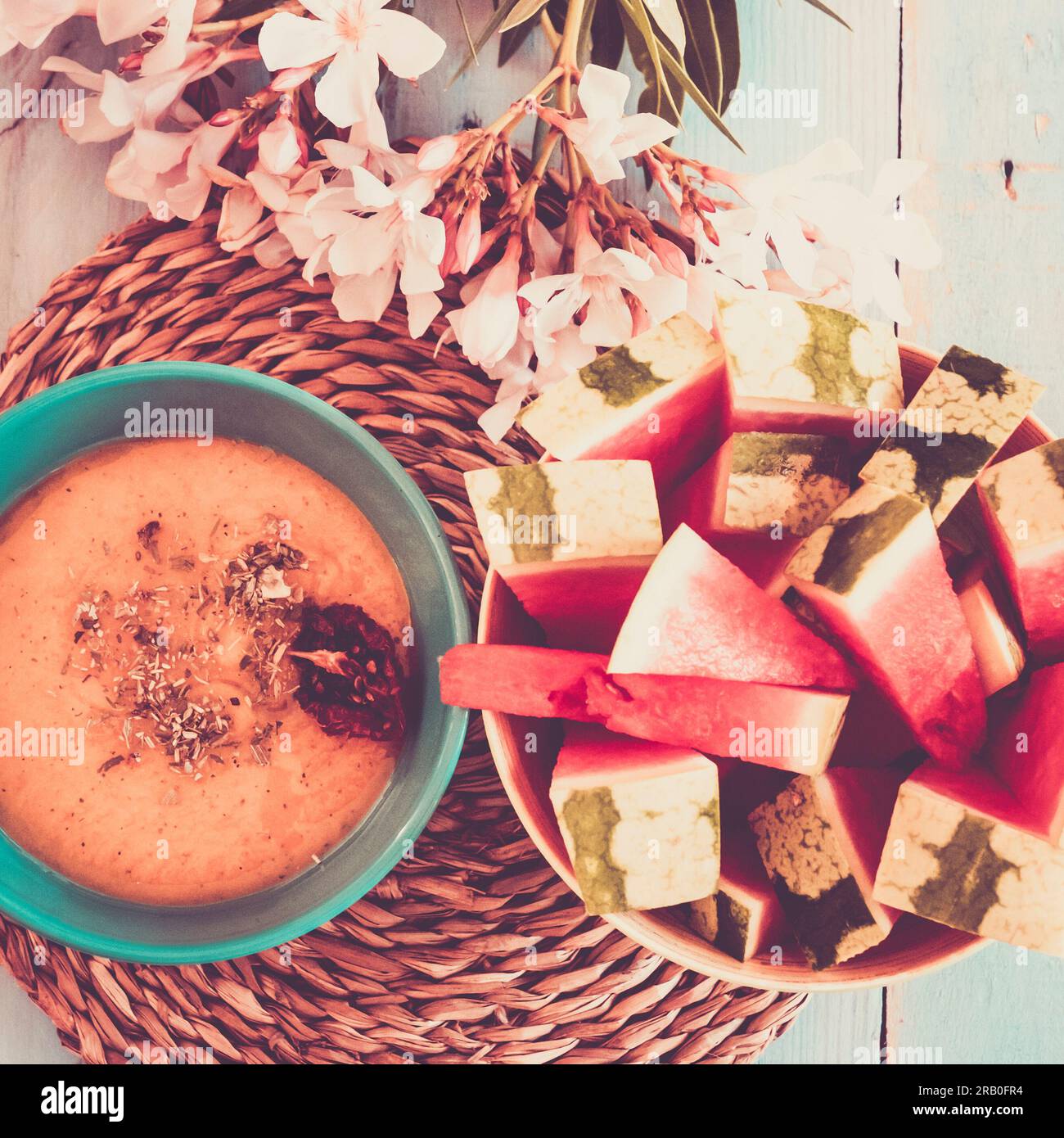 Top view composition of healthy food and lifestyle nutrition concept. Vegetarian and vegan vegetables soup with red watermelon fruit on a blue table ready for light lunch without calories. No people Stock Photo