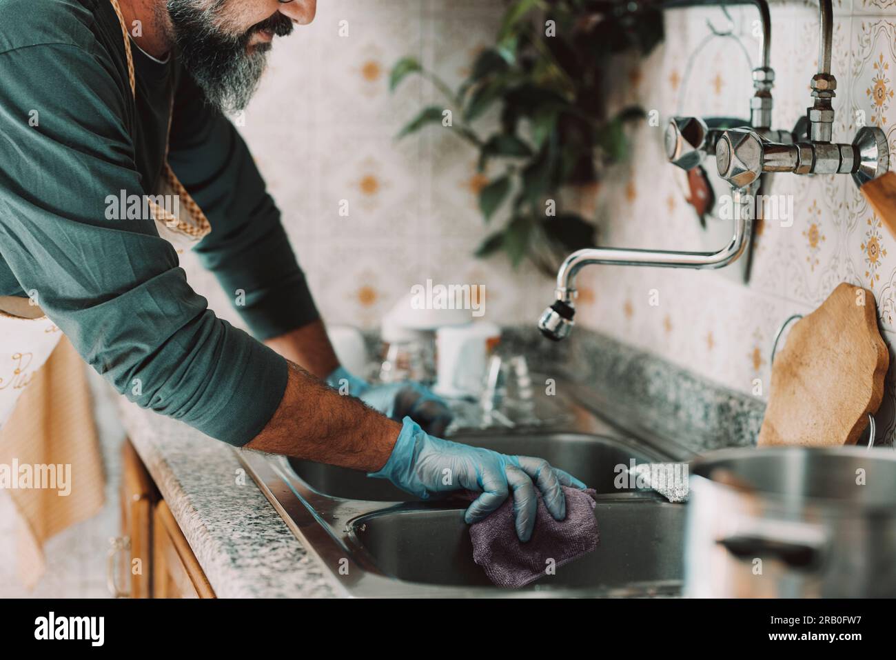 https://c8.alamy.com/comp/2RB0FW7/close-up-of-man-at-home-cleaning-the-kitchen-after-cooking-and-washing-the-dishes-alone-male-people-lifestyle-husband-doing-housework-hygiene-keeping-home-clean-feminine-work-done-by-male-indoor-2RB0FW7.jpg