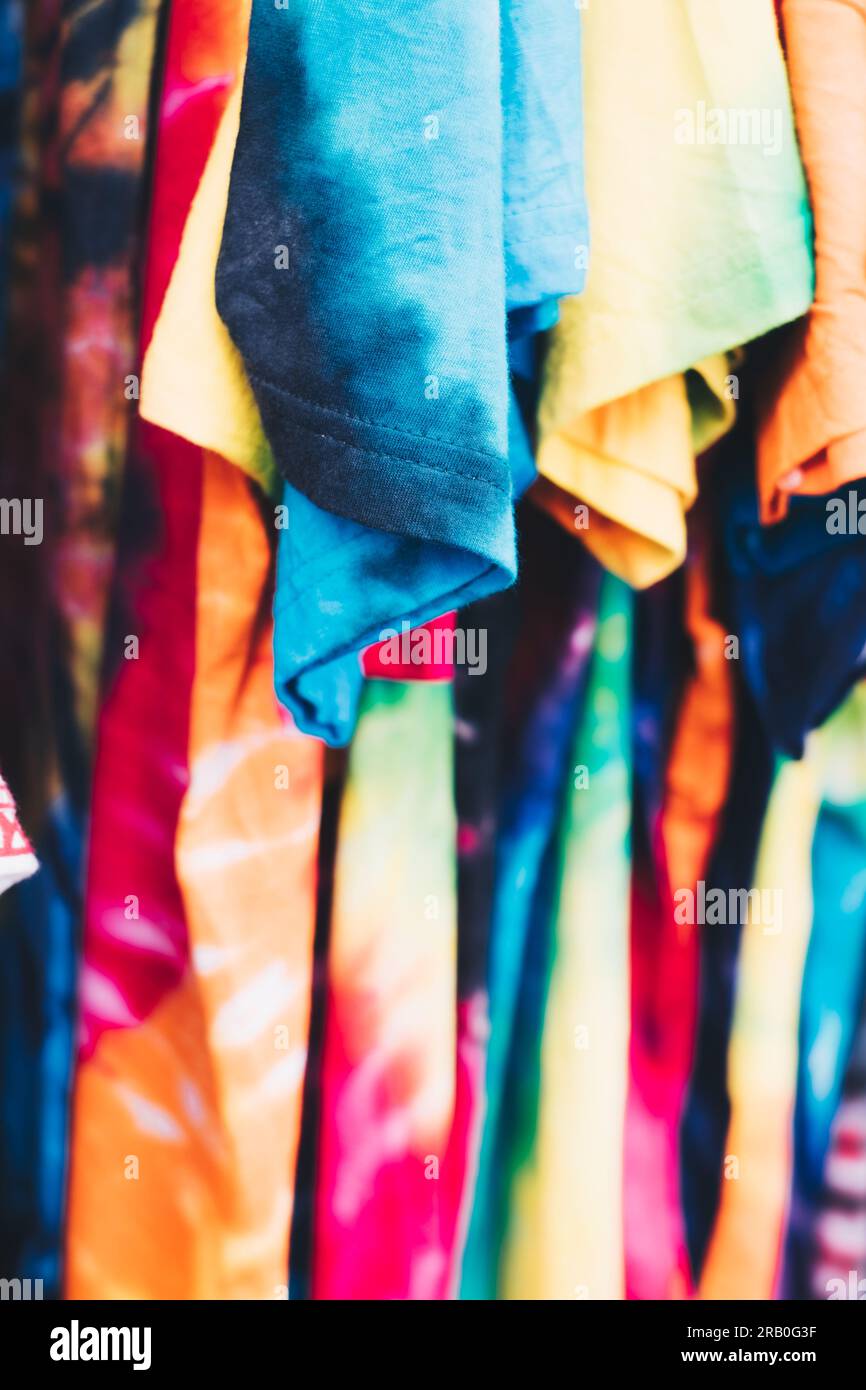 Array of colorful unisex tie-dye shirts. Selective focus. Closeup. Stock Photo