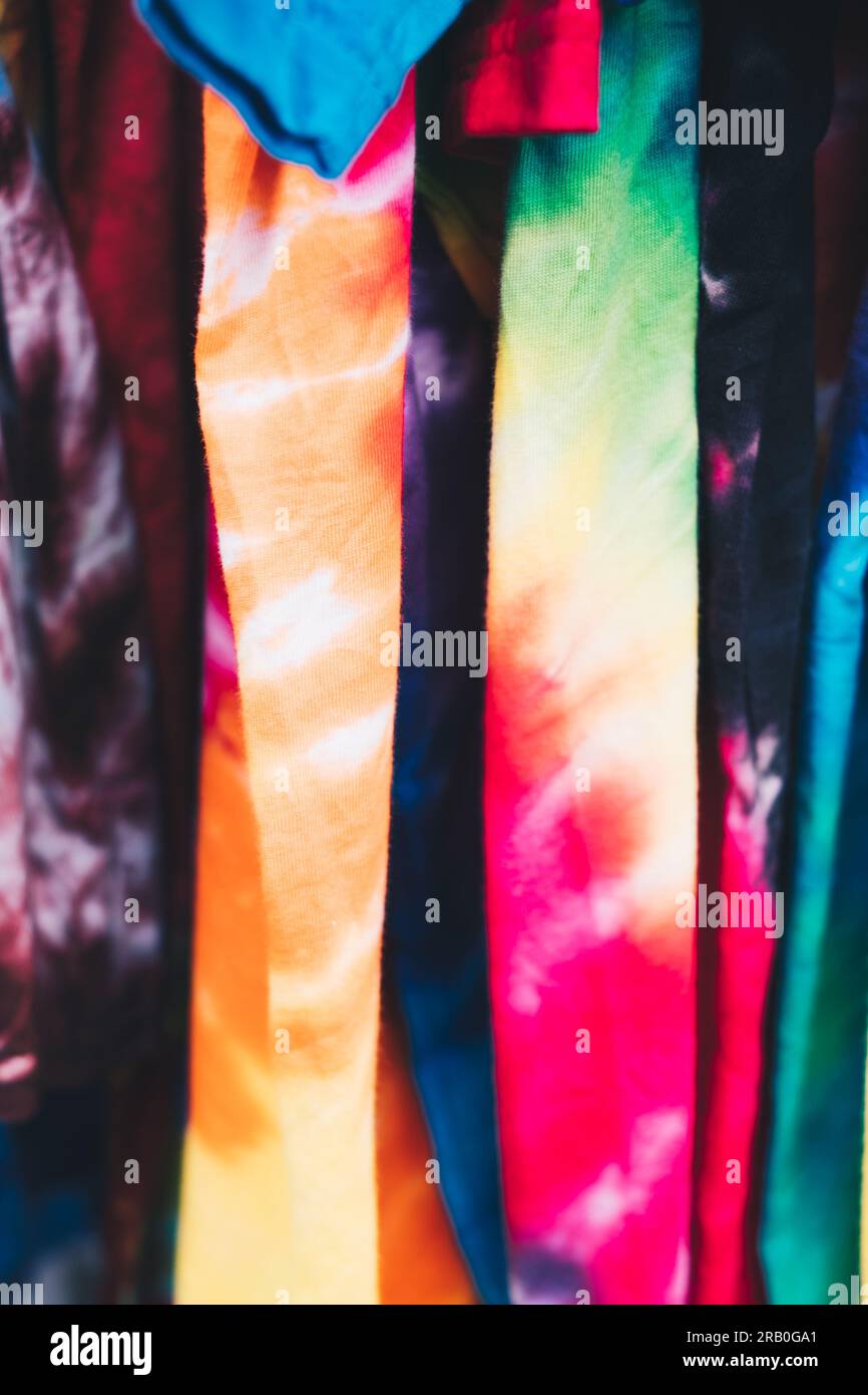 Array of colorful unisex tie-dye shirts. Selective focus. Closeup. Stock Photo
