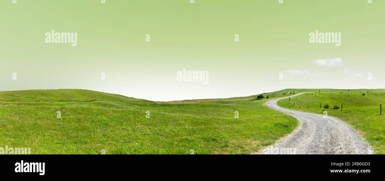 The way Forward through a green hilly landscape Stock Photo