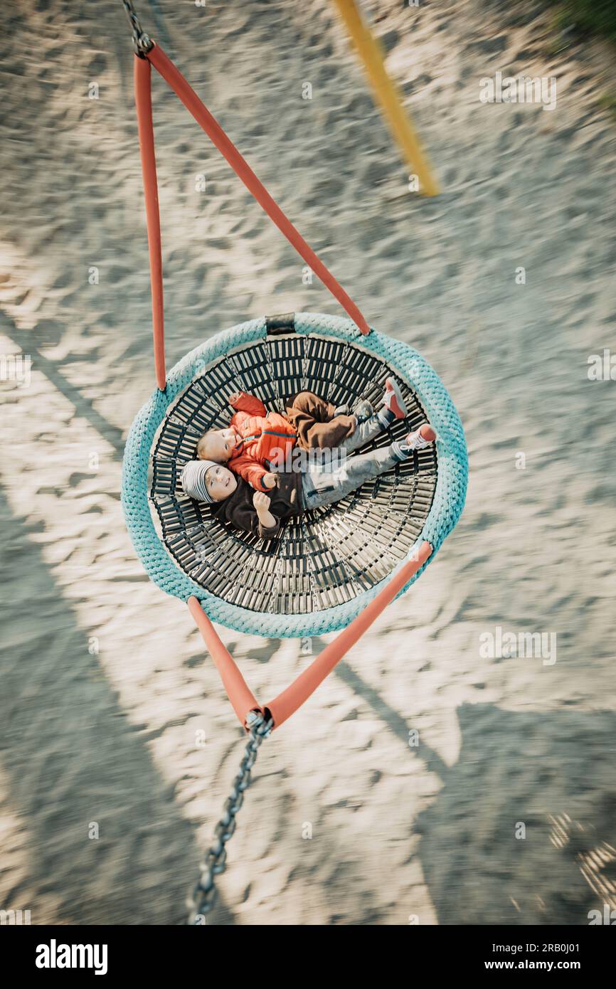 Brother and sister on a swing Stock Photo