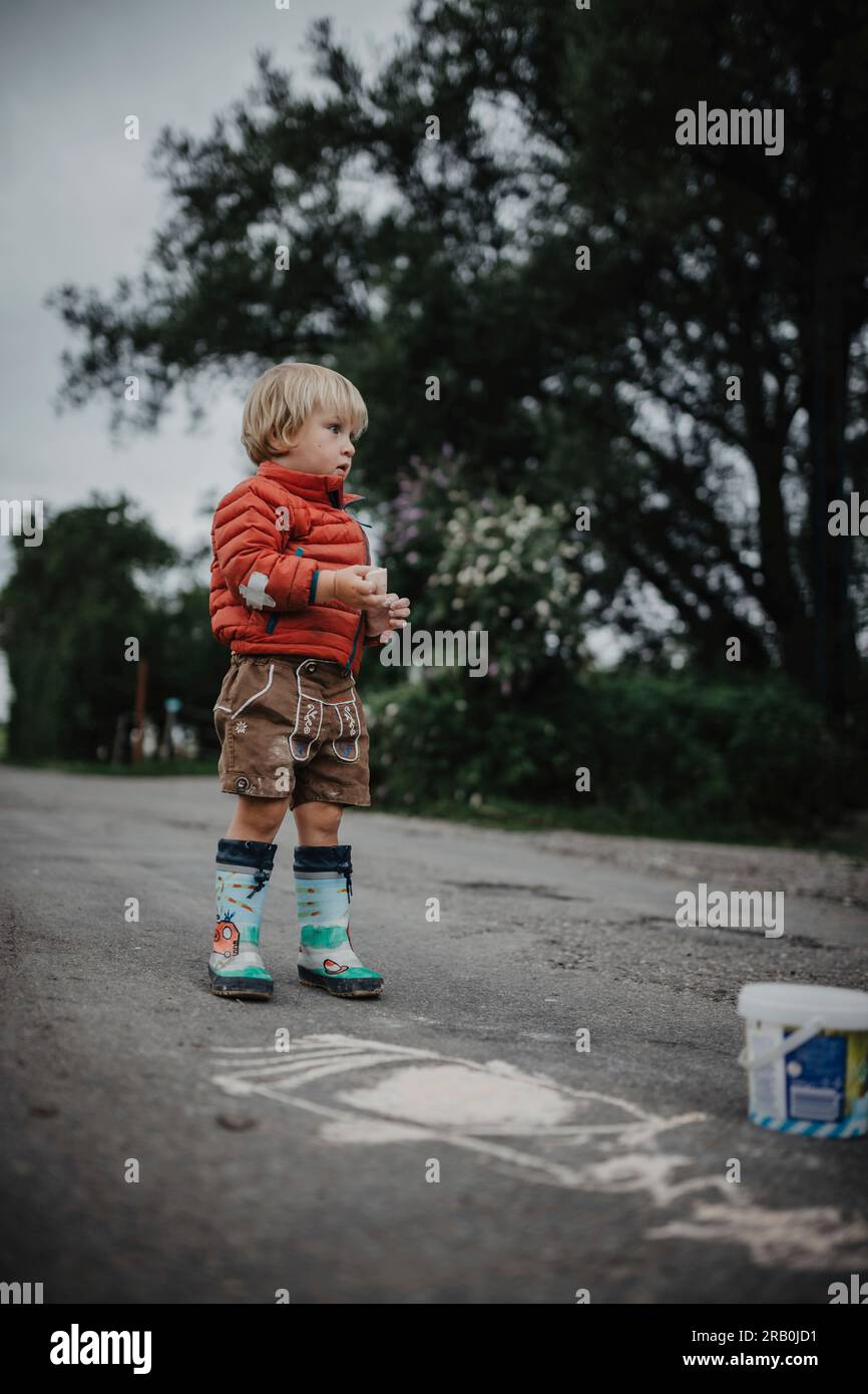 Little boy drawing with chalk on the street Stock Photo - Alamy