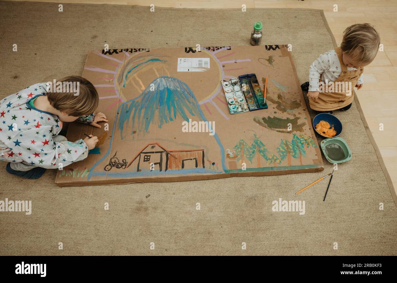 Brother and sister paint a picture on the floor Stock Photo - Alamy