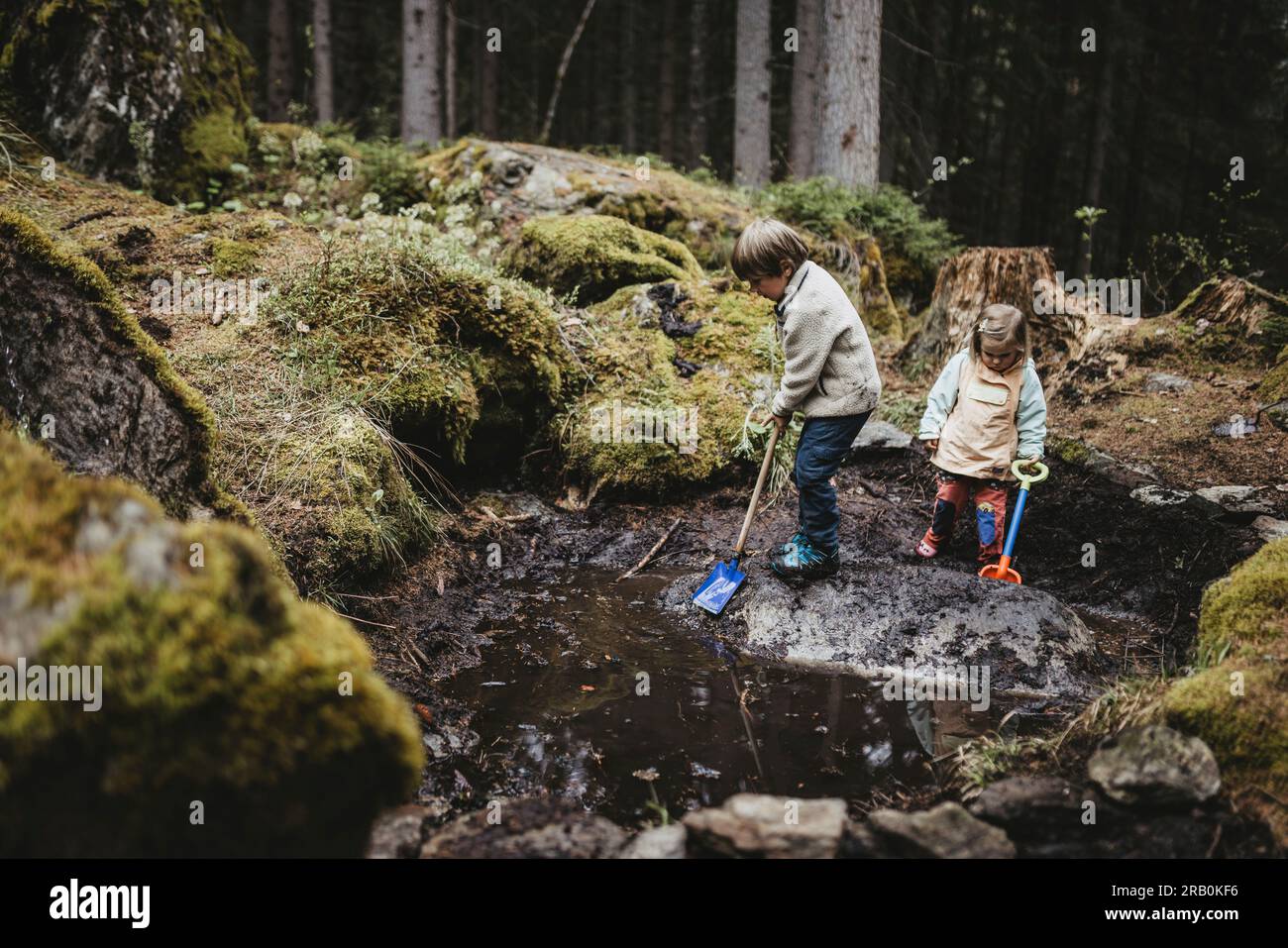Brother and sister playing by the stream in the forest Stock Photo - Alamy