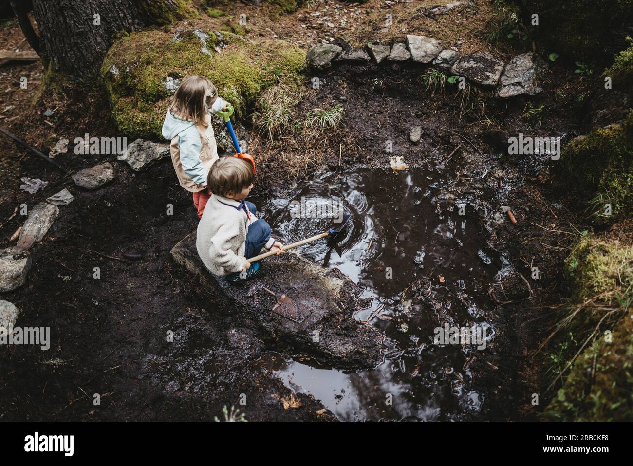 Brother and sister playing by the stream in the forest Stock Photo - Alamy