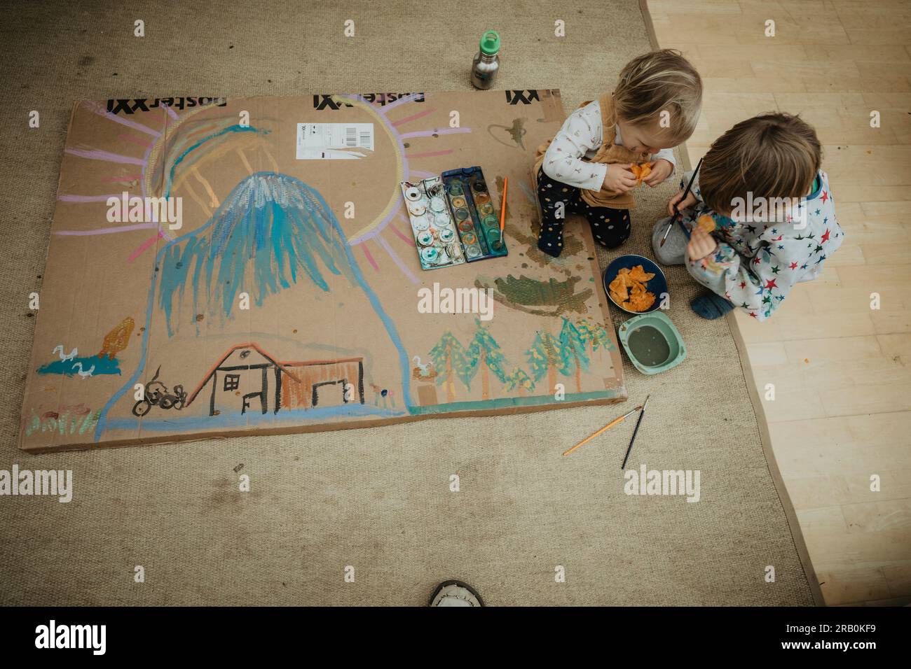 Brother and sister paint a picture on the floor Stock Photo - Alamy