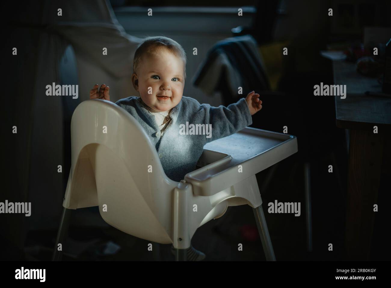 Baby sitting in high chair Stock Photo