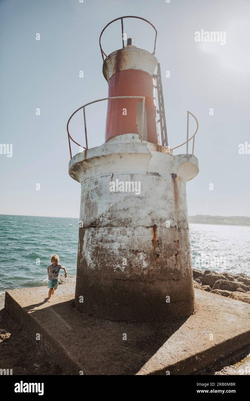 Boy running around lighthouse stock photo alamy