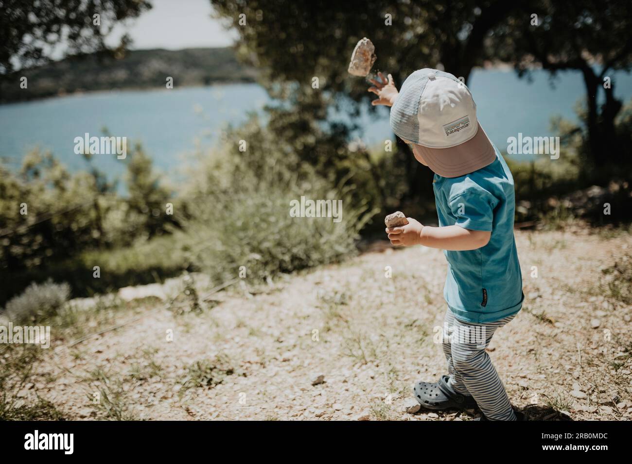 Boy throwing a stone by the sea, island Krk, Croatia Stock Photo