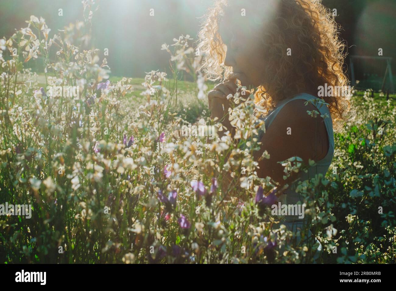 Woman feel emotion standing in the middle of blossom flowers meadow