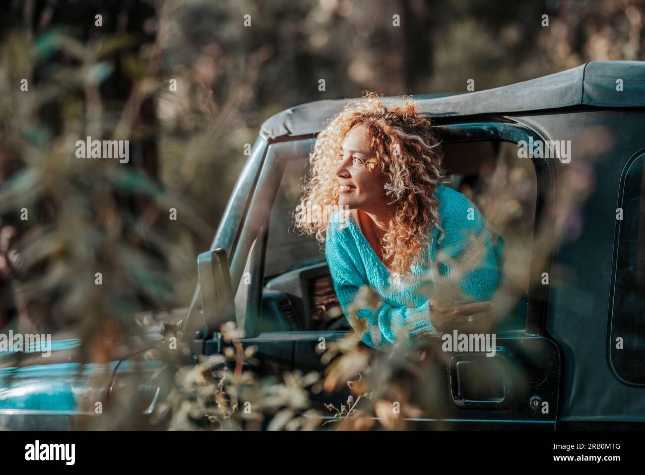 Travel and freedom adventure with car and female. One woman enjoying destination outside the window of her car transport. Concept of free lifestyle. Off road car and people. Weekend activity outside Stock Photo