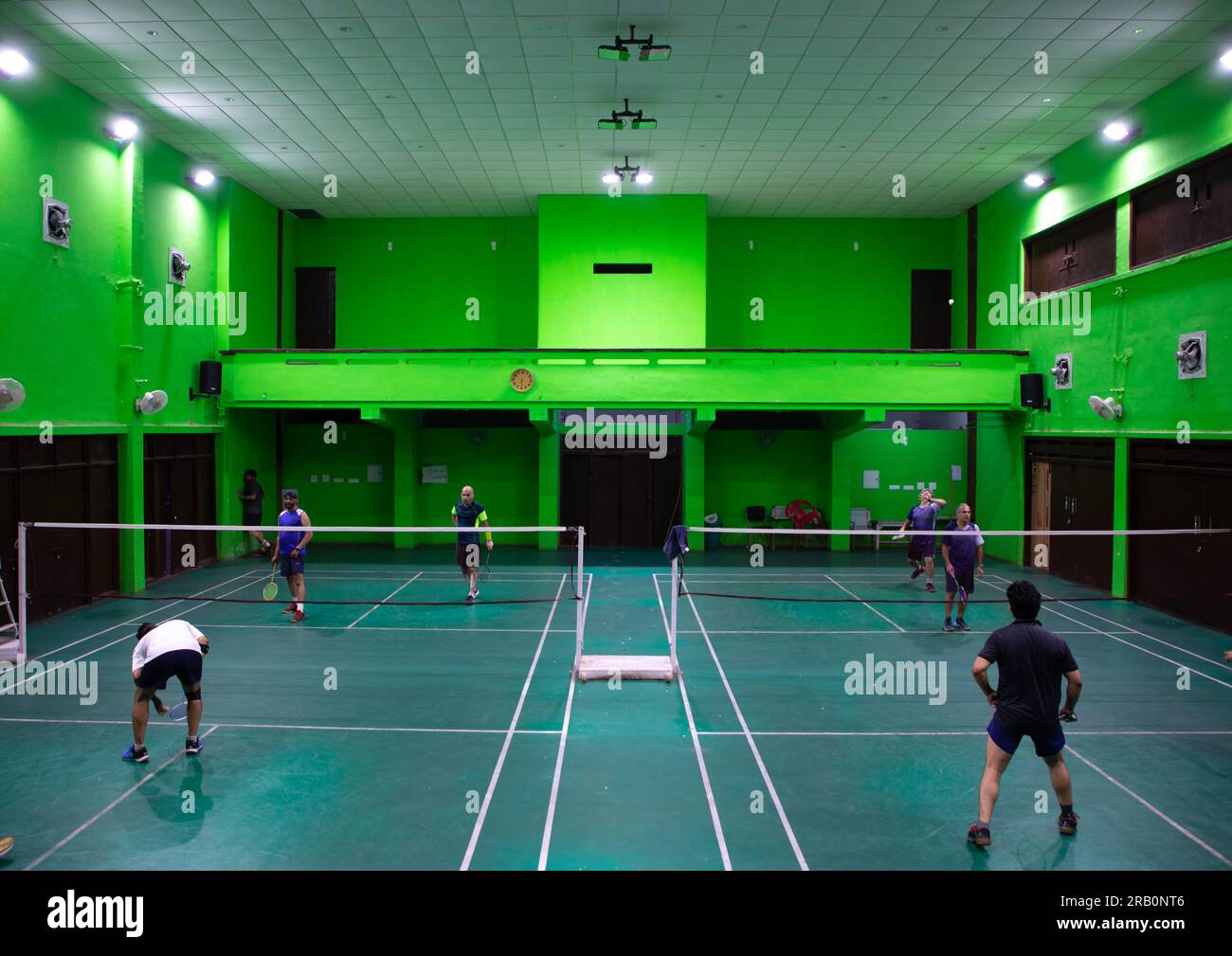 Men playing badminton in a former theatre inside model senior secondary