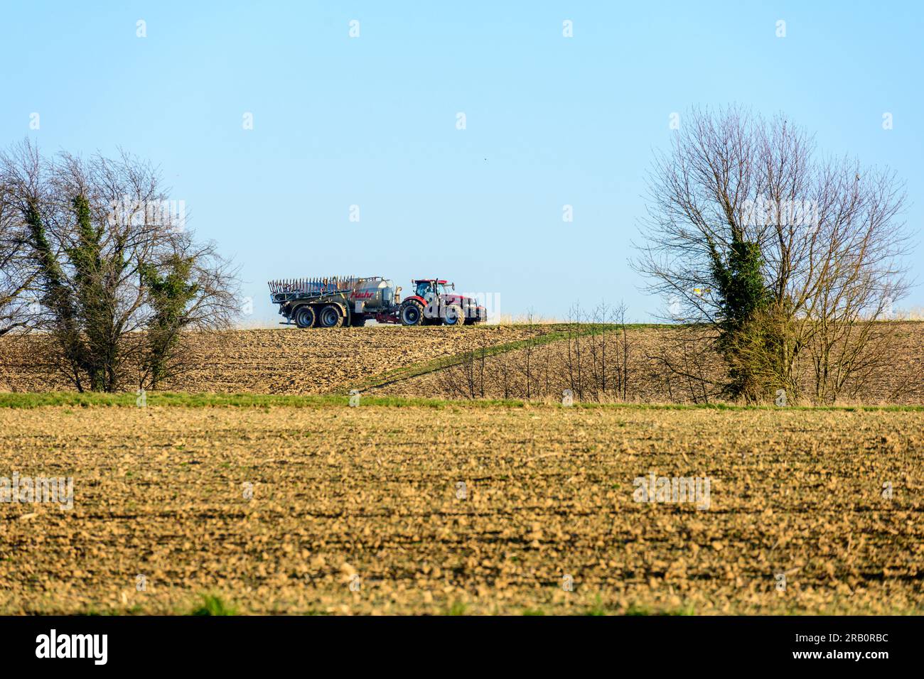 Farmer with tractor on the field Stock Photo - Alamy