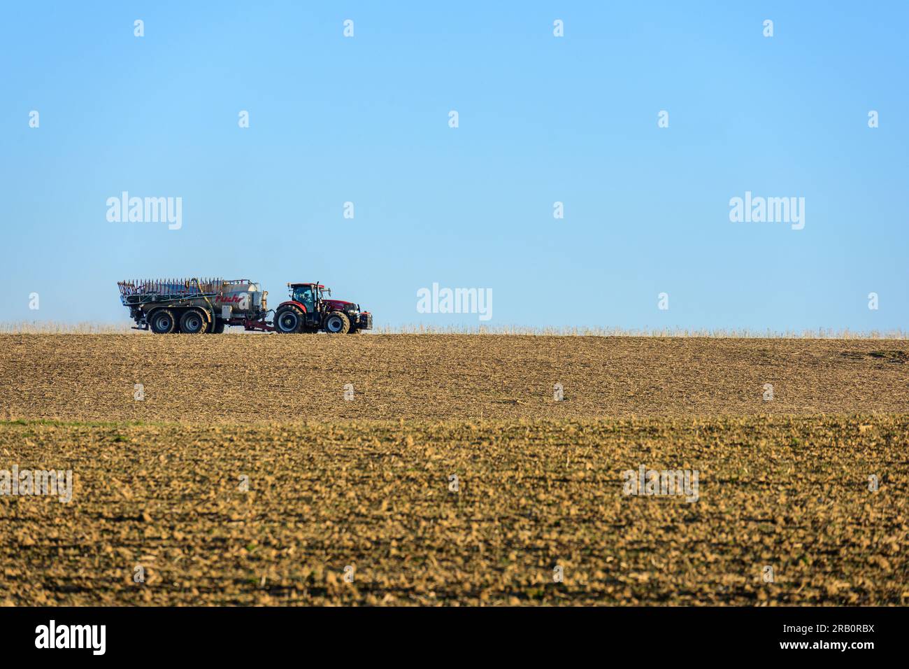 Farmer with tractor on the field Stock Photo - Alamy