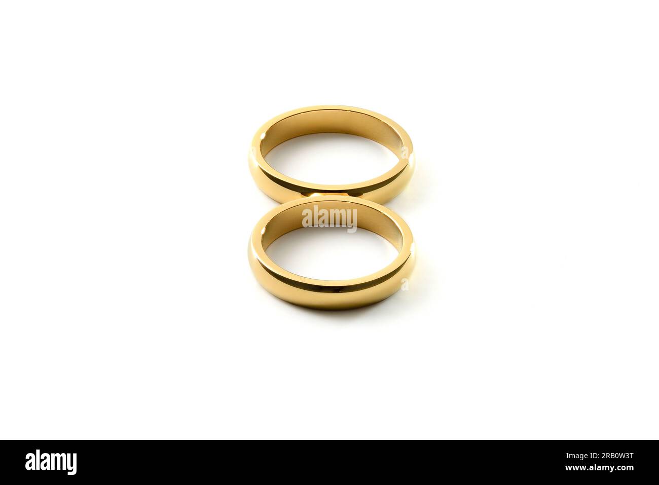 Detail of engagement gold rings forming an eight on white isolated