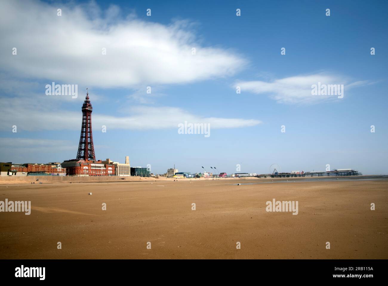 Blackpool's sandy beach showing Blackpool Tower with Central Pier in the distance. Stock Photo