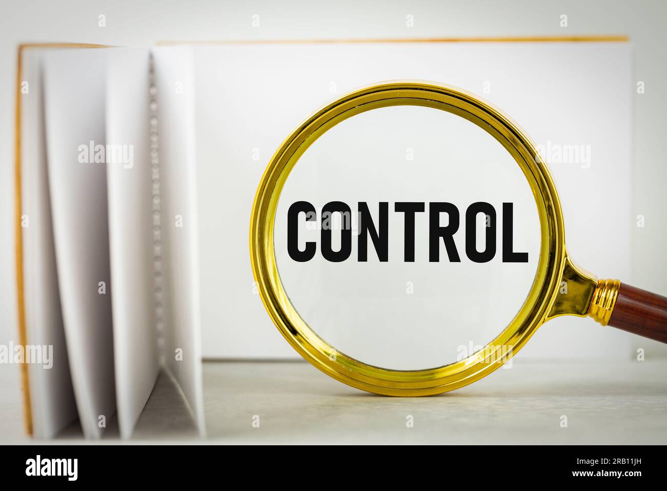 magnifying-glass-and-notepad-with-the-word-control-control-concept