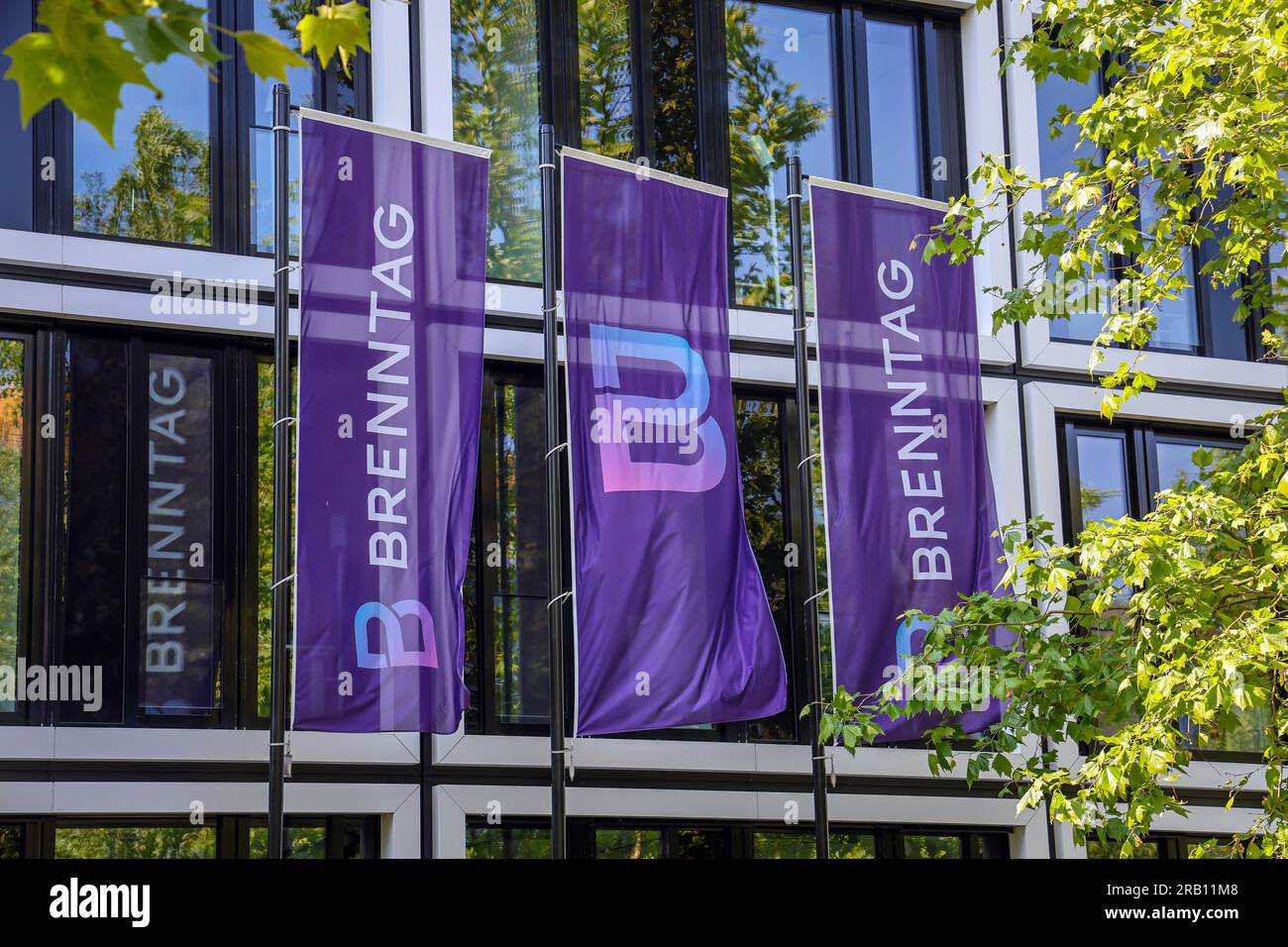 Essen, North Rhine-Westphalia, Germany - Brenntag, company logo on flags in front of the facade of the Brenntag headquarters, the company is the world market leader in the distribution of chemicals and ingredients Stock Photo
