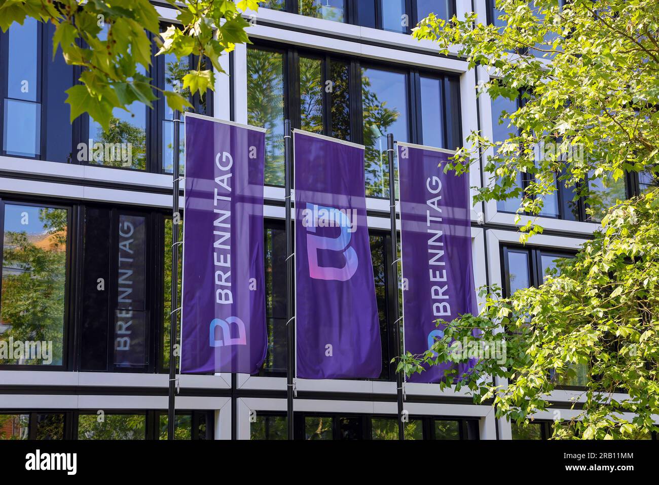 Essen, North Rhine-Westphalia, Germany - Brenntag, company logo on flags in front of the facade of the Brenntag headquarters, the company is the world market leader in the distribution of chemicals and ingredients Stock Photo