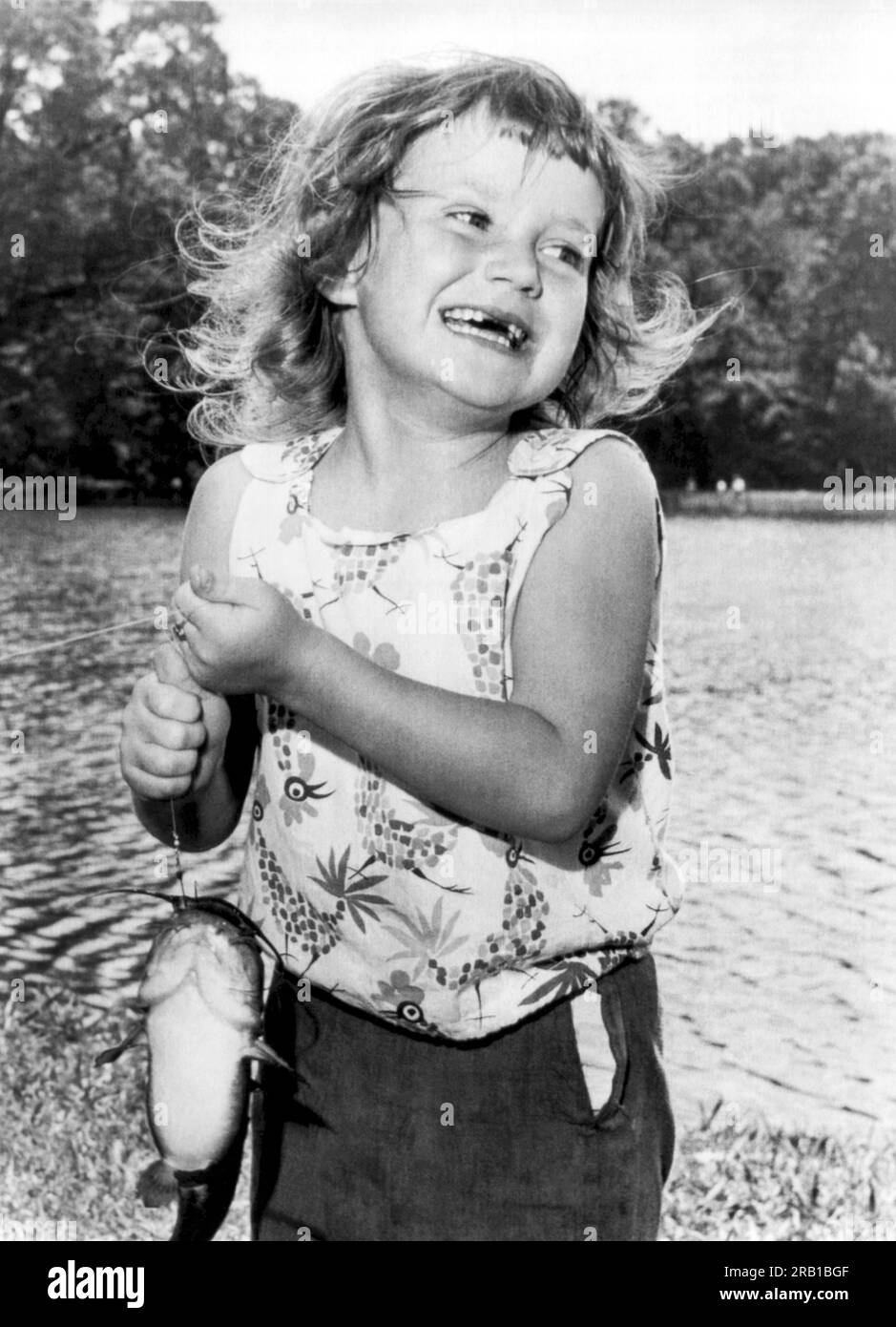 Memphis, Tennessee:  c. 1960 A happy six year old girl lands a catfish during the fishing rodeo. Stock Photo