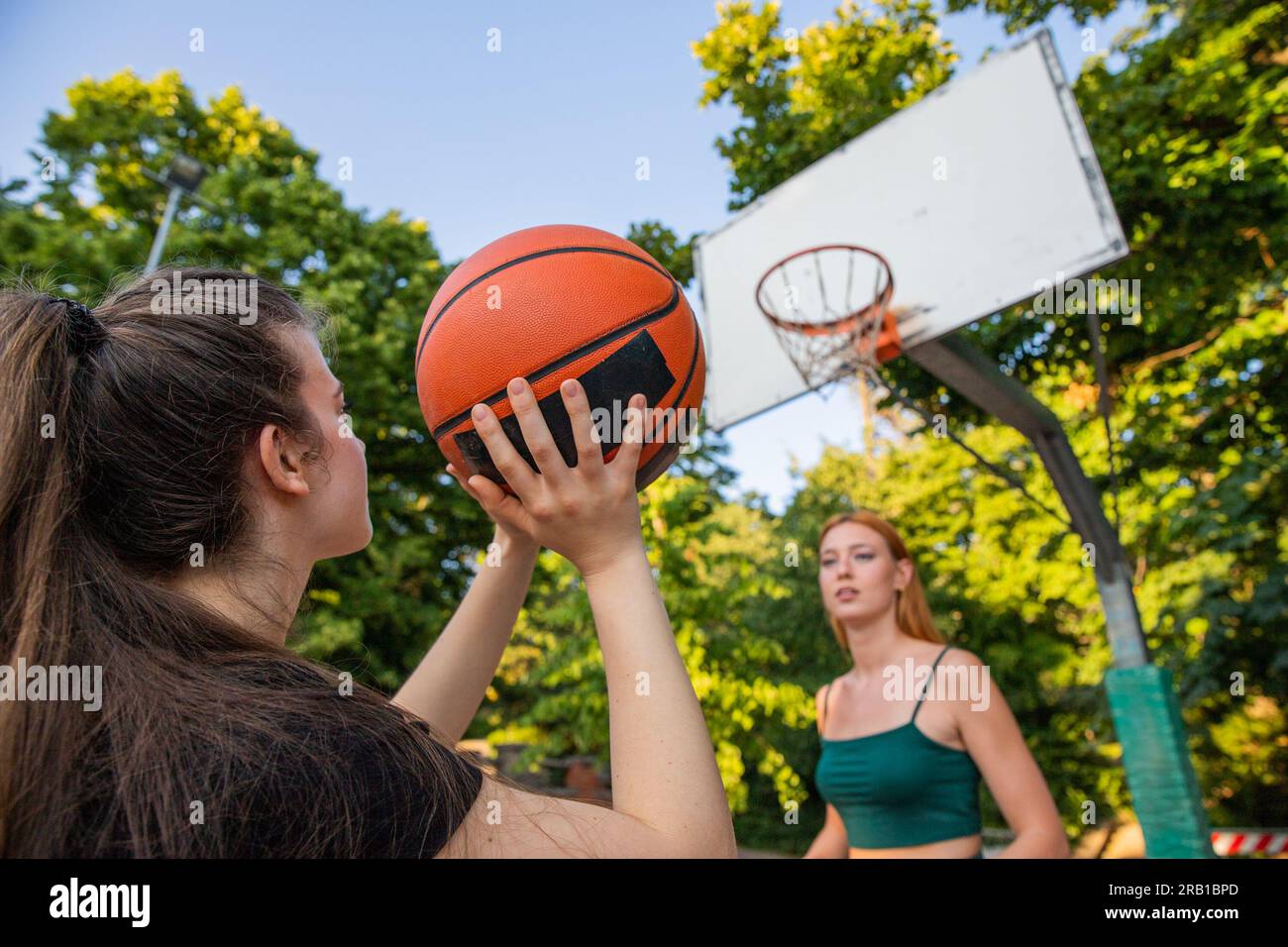 A basketball player is about to shoot and the other girl is defending during a game Stock Photo