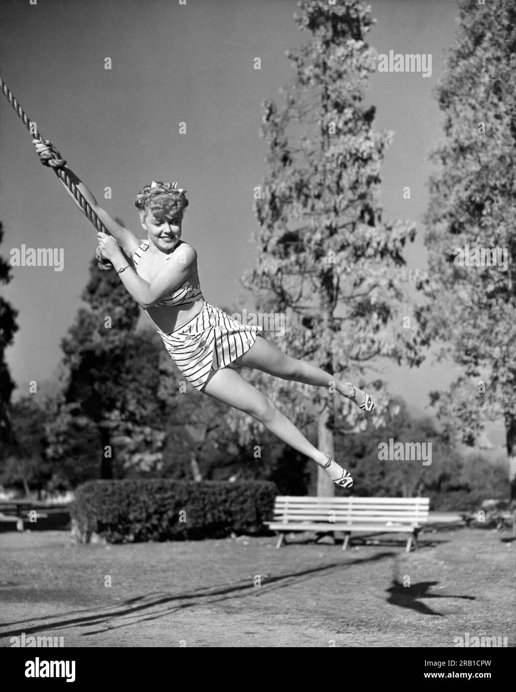 Hollywood, California: January 5, 1942 Actress Phyllis Ruth swings into the scene on a rope. Stock Photo