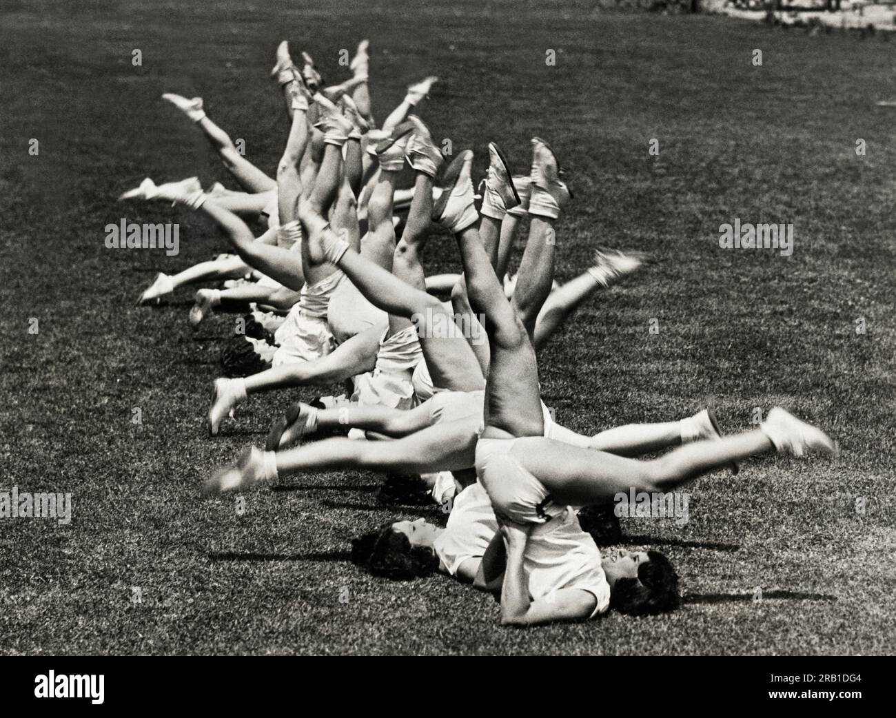 Los Angeles, California,  1930 Working out in Lafayette Park, members of the Los Angeles Physical Culture Club call this 'riding a bicycle', an exercise they developed for 'taking off where there's too much and putting on where there's too little'. Stock Photo